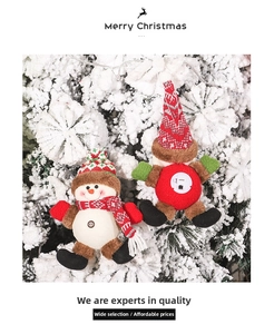 Close-up of lighted Christmas plush snowman and elf ornaments on a snowy tree