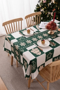 Detail view of green and white plaid Christmas tablecloth with snowflake and gingerbread prints