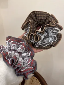 Detail of vintage red and brown checkered hair scrunchies with white lace edges