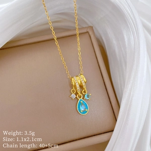 Detailed macro shot of gold teardrop pendant with blue stone and turquoise enamel