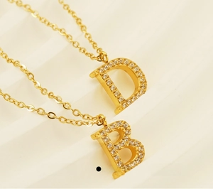 Macro shot of gold-plated stainless steel letter pendants with pavé-set rhinestones