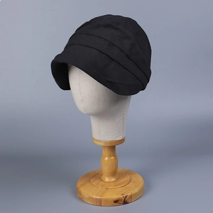 Detail view of the layered pleat design on a black short brim cotton sun hat