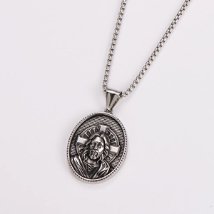 Macro shot of silver metal necklace with vintage religious Jesus portrait relief pendant