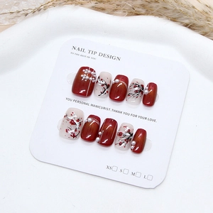 Handmade burgundy cat eye press-on nails with white plum blossoms and pearl accents