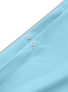 Close-up of sky blue waffle fabric texture and white button detail on men's polo shirt