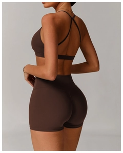 Detail of cross-back straps and high-waist shorts on dark brown yoga two-piece set