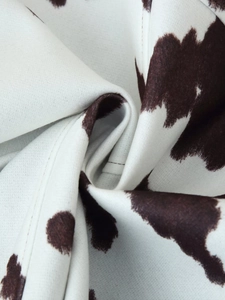 Detailed macro view of soft cow print fabric texture with fine stitching on casual jacket