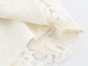 Détail de la bordure en dentelle florale blanche et du tissu d'une robe de style français