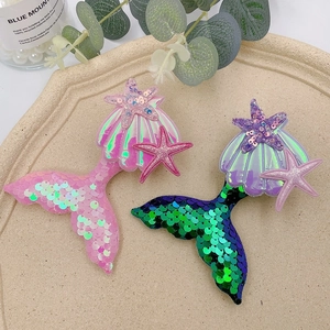 Detailed view of sequined mermaid tail hair clips with colorful shells and starfish decor