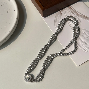 Close-up of double-layer dark gray pearl necklace with square zircon vintage pendant