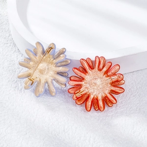 Detail view of the metal safety pin backing on daisy flower brooches for clothing