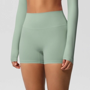 Detailed view of high-waist seamless compression fabric on green yoga shorts