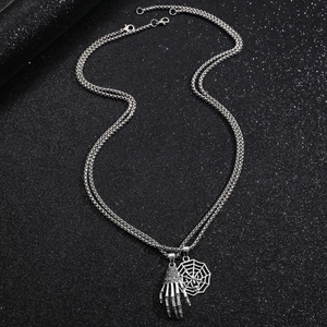 Detail of gothic silver skeleton hand and spider web pendants on dual layer chain
