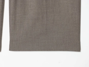 Detailed close-up of taupe twill fabric texture and neat stitching on formal suit pants