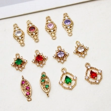 Flat lay of gold-plated rectangular and oval pendants with colorful zircon inlays