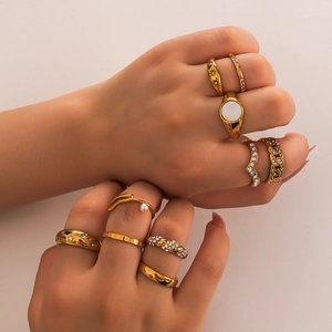 Stackable gold stainless steel rings set with crystals and pearls on model hands