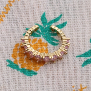 Gold plated heart ring with pink zircon stones on a rustic pineapple pattern background