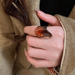 Détail d'une bague ovale en résine ambre sur un anneau doré de style vintage