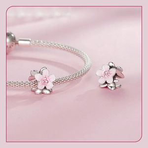 Macro shot of S925 sterling silver cherry blossom charm with pink enamel detail
