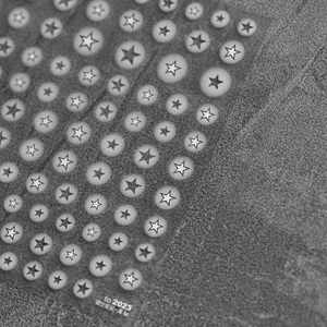 Macro detail of dark grey star-shaped nail art stickers with hollow five-point pattern