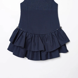 Mini robe à carreaux bleu marine avec volants superposés et détails d'oeillets en métal