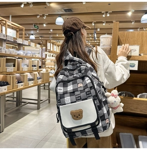 Detail showing checkered patterns with bear embroidery and plush bunny on a cute backpack