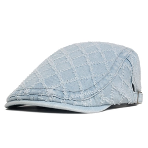 Detail of light blue washed denim beret featuring quilted diamond patterns and frayed edges