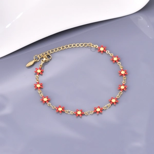 Détail du bracelet chaîne dorée avec fleurs en émail rouge et jaune et fermoir mousqueton
