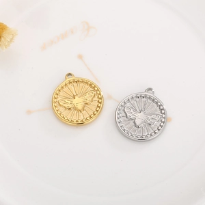 Detailed close-up of gold and silver bee embossed round pendants with bead edge