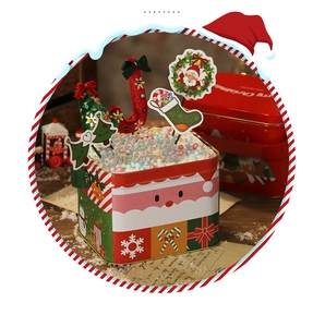 Primo piano di una scatola di latta natalizia festiva con design di Babbo Natale e glitter