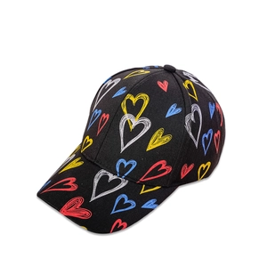 Close-up of black baseball cap with colorful heart graffiti patterns and curved brim