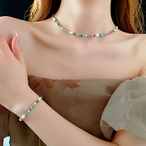 Detailed macro of 18K gold plated jewelry set with colorful seed beads and pearls