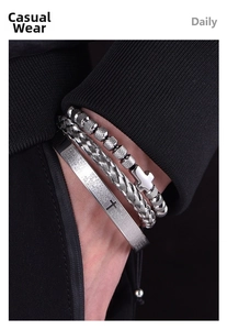 Detailed view of men's silver stainless steel twisted bracelet and engraved cross bead set