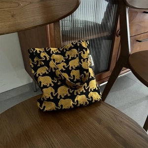Détail du tissu jacquard d'éléphant doré et de l'étiquette de marque sur le sac en toile