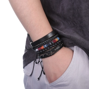 Détail de bracelets multicouches en cuir noir avec ancres et perles tissées ethniques