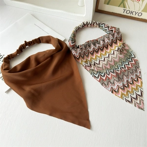 Detail of retro brown and zigzag pattern bandanas with elastic headbands on white background