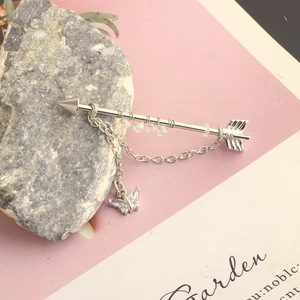 Detailed view of silver arrow industrial barbell earring with a butterfly chain pendant