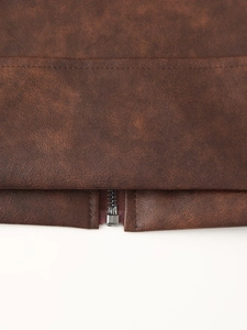 Détail de la fermeture éclair métallique et des coutures sur la veste en similicuir brun