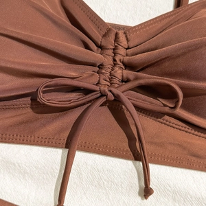 Detail view of coffee brown ribbed swimsuit fabric with ruched center and drawstring tie