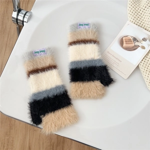 Detail of colorful striped fuzzy fingerless gloves with a soft knit texture and brand label