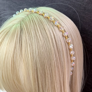 Detailed close-up of handmade crown headband with crystals and pearls on gold wire