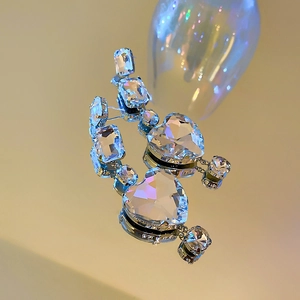 Detailed macro shot of silver heart earrings featuring dazzling rhinestones and crystals