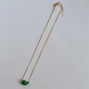 Detail of green teardrop pendant on gold stainless steel chain with adjustable slider