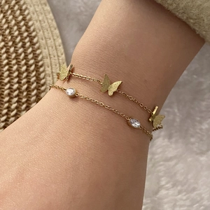 Detailansicht eines goldenen Schmetterlings und Zirkonia am zweilagigen Armband