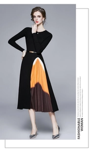 Détail d'une robe en tricot avec insert plissé orange et fine ceinture à boucle dorée