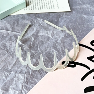 Detail of transparent wavy hairband with comb teeth for secure styling and non-slip grip