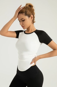 Detail of color-block yoga shirt featuring side ruching and curved hem for slim fit