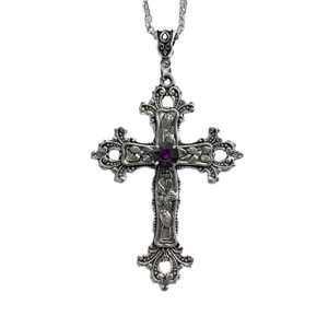 Detail of silver gothic cross pendant with purple gemstone and floral engravings