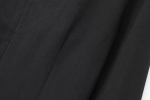 Vue macro du tissu noir montrant la texture fine et les détails de couture de haute qualité
