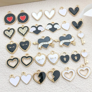Mix of 30 black and white enamel heart and wing charms with gold alloy plating